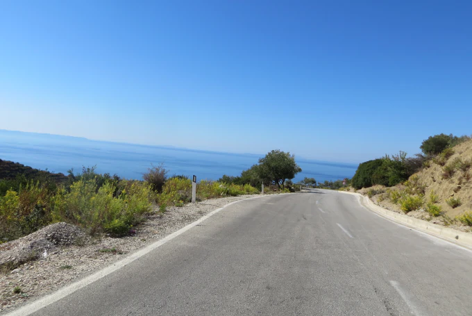 Malerische Küstenstraße zwischen Saranda und Vlora mit Panoramablick auf die albanische Riviera und das tiefblaue Ionische Meer.