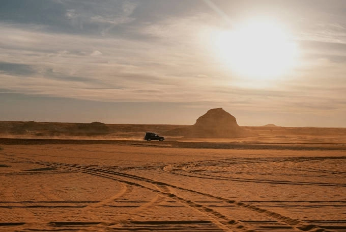 Bild: unsplash Geländefahrzeug fährt bei Sonnenuntergang durch die Weiße Wüste in Ägypten