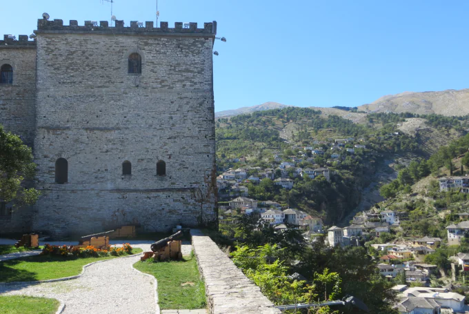Burg von Gjirokaster mit historischem Steinturm und Kanonen.