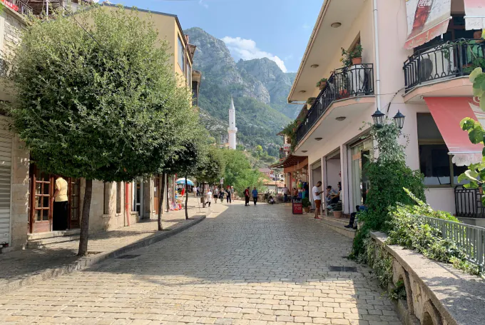 Fußgängerzone in Kruja nahe dem Alten Basar mit Murad-Bey-Moschee und Kruja-Gebirge.