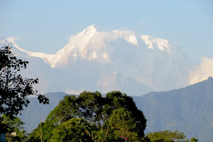 Schneebedeckte Himalaya-Gipfel in Nepal mit Blick vom Dorf Nalma in der Region Lamjung über dichte Bergwälder